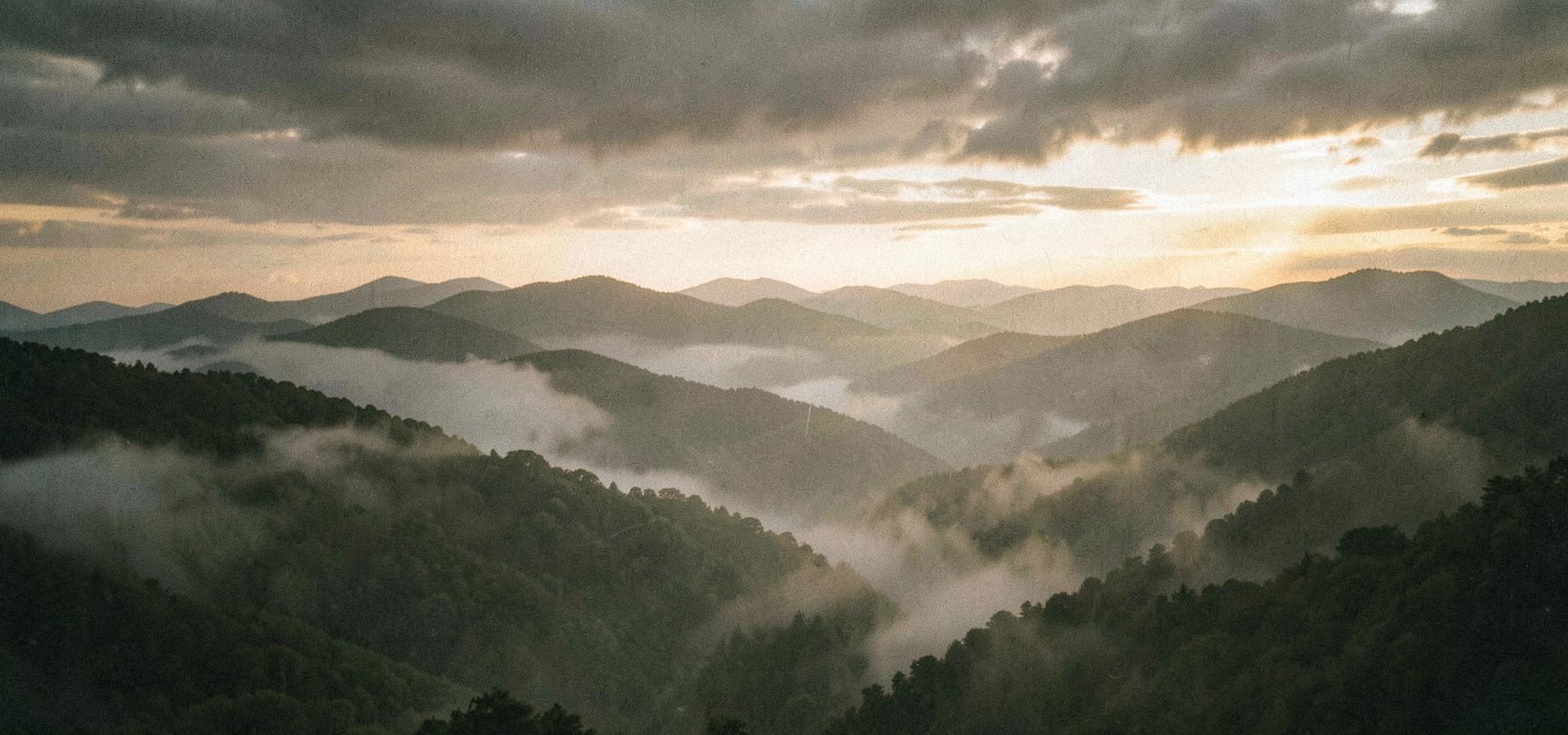 Fog rolling through layered Blue Ridge mountain ridgelines at dawn